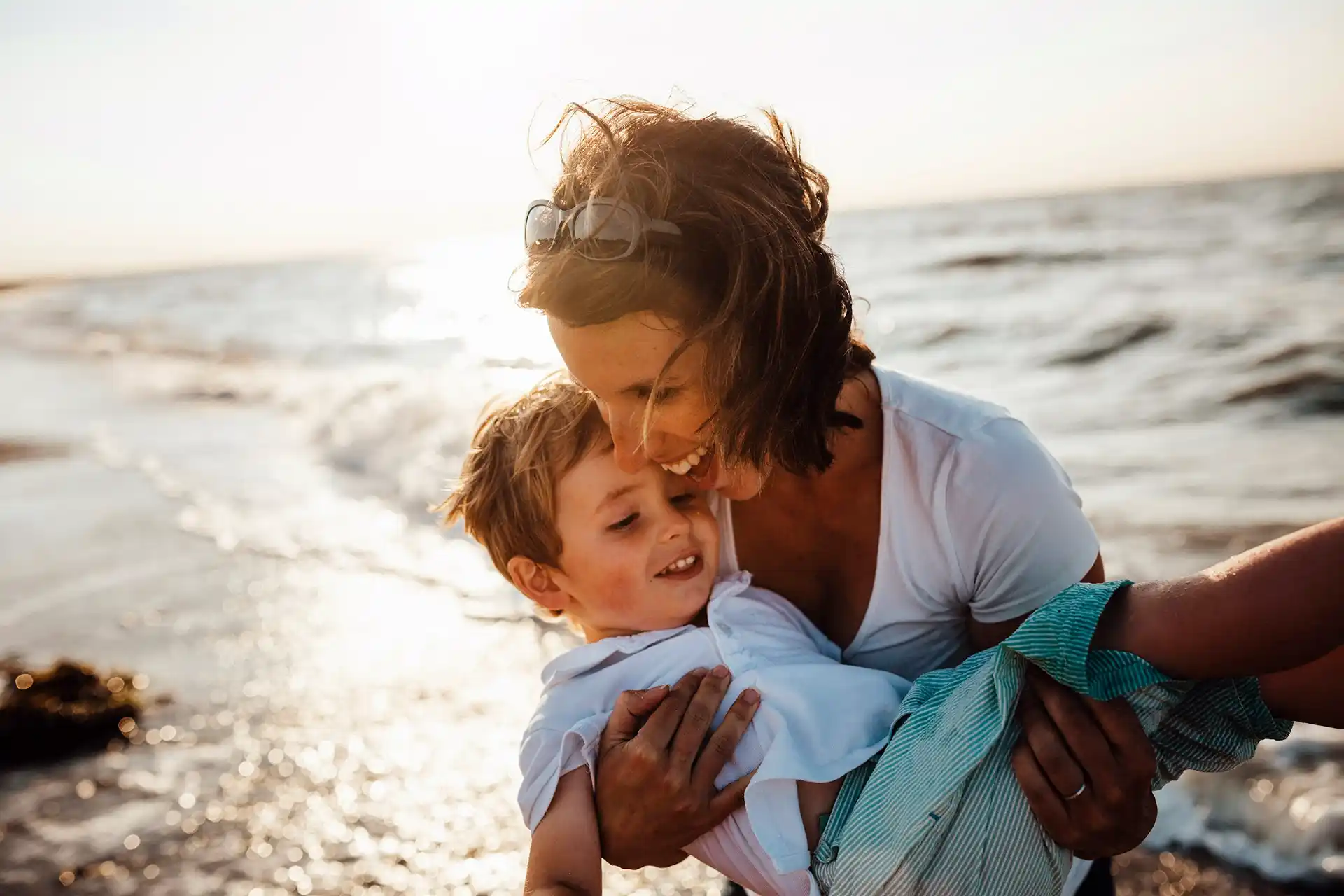 Mother holding son on the beach